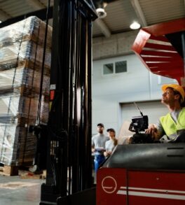 forklift-operator-loading-cargo-while-working-warehouse-his-colleagues-are-background